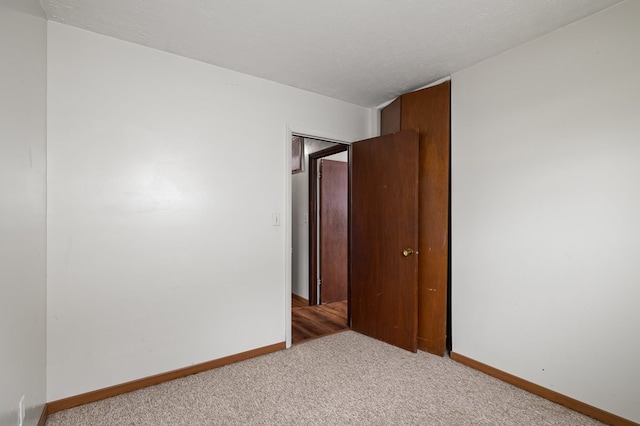 empty room with carpet floors and a textured ceiling