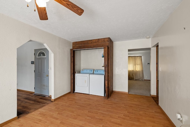 interior space with wood-type flooring, washing machine and clothes dryer, and a textured ceiling