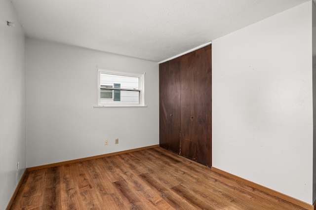 spare room featuring wood-type flooring and a textured ceiling