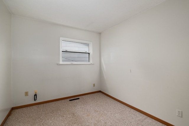 carpeted spare room featuring a textured ceiling