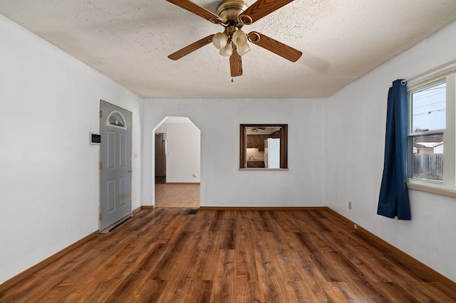 unfurnished room with dark wood-type flooring, ceiling fan, and a textured ceiling