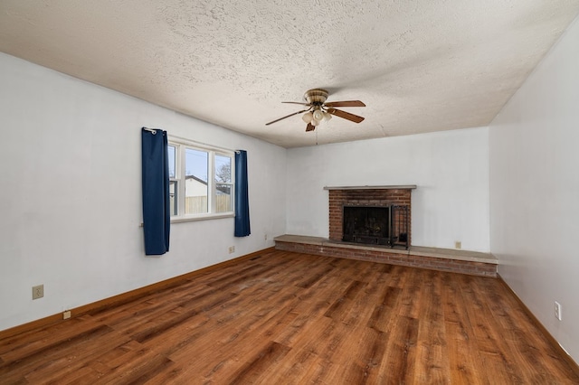 unfurnished living room with a fireplace, a textured ceiling, wood-type flooring, and ceiling fan