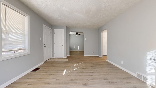 interior space featuring ceiling fan, a textured ceiling, and light wood-type flooring