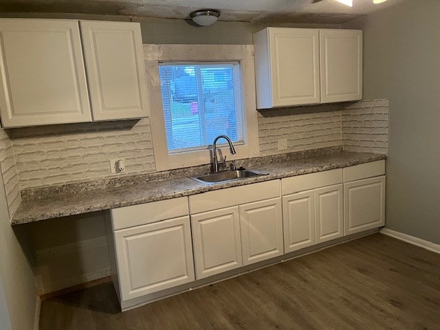 kitchen with dark hardwood / wood-style flooring, white cabinetry, sink, and tasteful backsplash