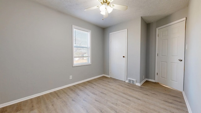 unfurnished bedroom featuring ceiling fan, a textured ceiling, and light hardwood / wood-style floors