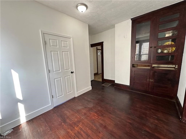 85 Penn Ave, Mansfield, OH 44903 - empty room featuring a textured ceiling, dark wood-style floors, and baseboards