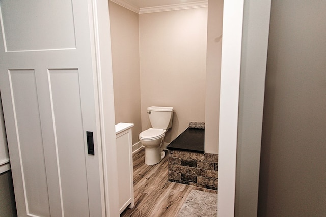 bathroom with toilet, ornamental molding, wood-type flooring, and vanity