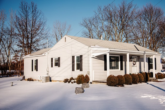 snow covered property with central AC