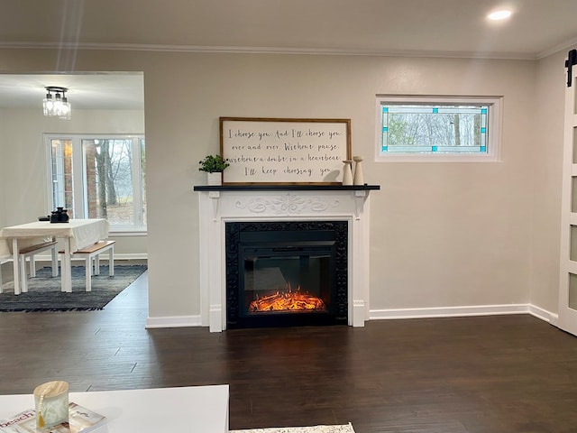 unfurnished living room featuring a glass covered fireplace, crown molding, baseboards, and dark wood-type flooring
