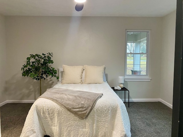 bedroom featuring baseboards and dark carpet
