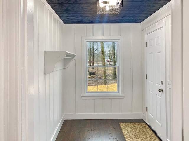entryway featuring dark wood finished floors, a decorative wall, and baseboards