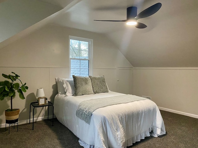 bedroom with dark colored carpet, baseboards, ceiling fan, and vaulted ceiling