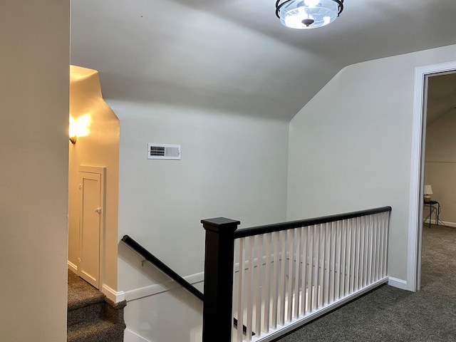 stairs featuring baseboards, visible vents, carpet floors, and lofted ceiling