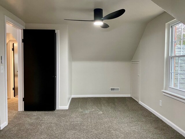 additional living space featuring visible vents, baseboards, vaulted ceiling, carpet flooring, and a ceiling fan