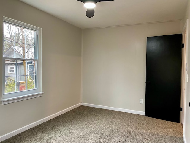unfurnished room with baseboards, a ceiling fan, and carpet floors