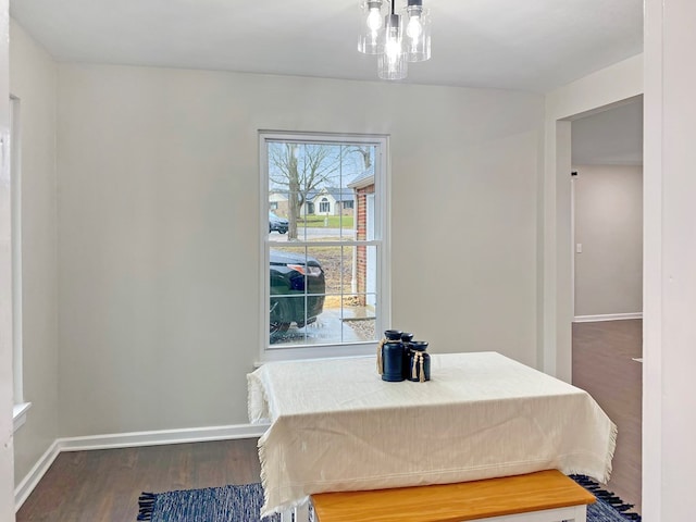 dining area with a chandelier, baseboards, and wood finished floors