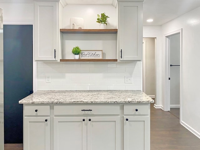 kitchen featuring light stone counters, baseboards, open shelves, dark wood-style flooring, and backsplash