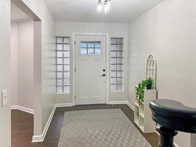 foyer featuring dark wood finished floors and baseboards