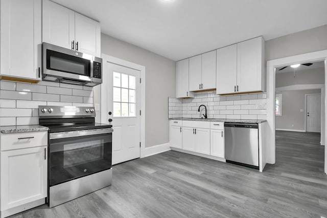 44 W 4th St, Fredericktown, OH 43019 - kitchen with stainless steel appliances, baseboards, a sink, and decorative backsplash