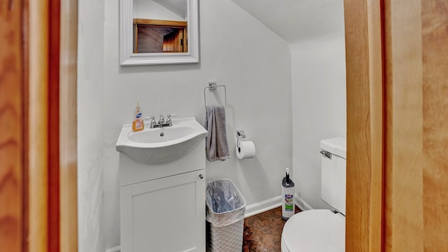 bathroom featuring vanity, toilet, and vaulted ceiling