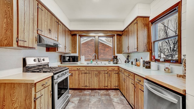 kitchen with appliances with stainless steel finishes, backsplash, and sink