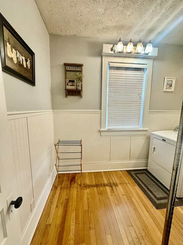 bathroom featuring washer / clothes dryer, a textured ceiling, and hardwood / wood-style flooring