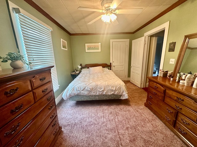 carpeted bedroom with ceiling fan and ornamental molding