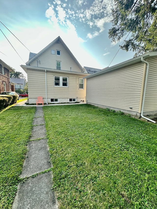 rear view of property featuring a yard