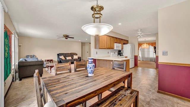 dining area featuring ceiling fan with notable chandelier and a textured ceiling