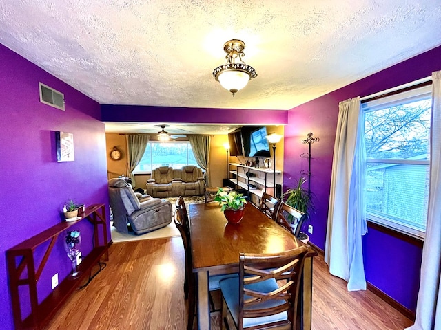 dining area with hardwood / wood-style flooring and a textured ceiling