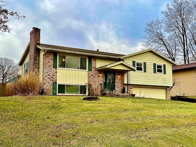 raised ranch featuring a garage and a front lawn