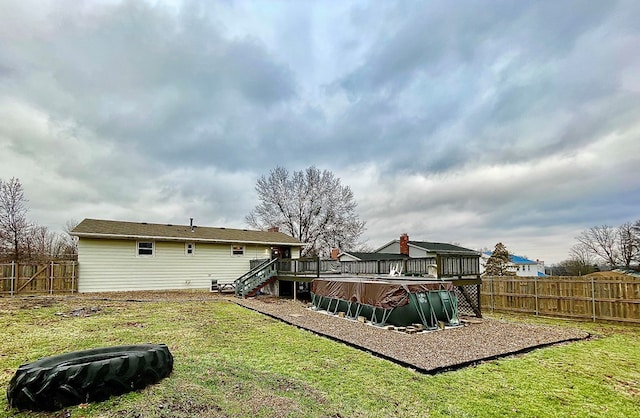 back of house featuring a pool side deck and a yard