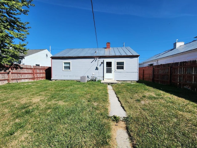 back of property with a yard and central AC unit