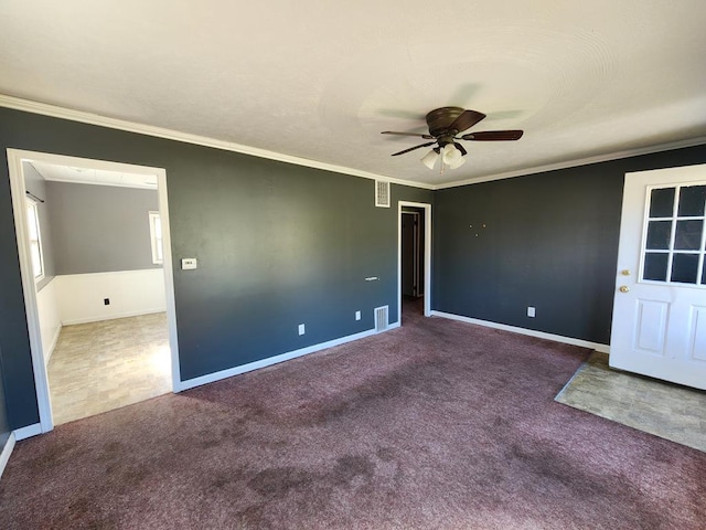 empty room featuring ceiling fan, dark carpet, and ornamental molding