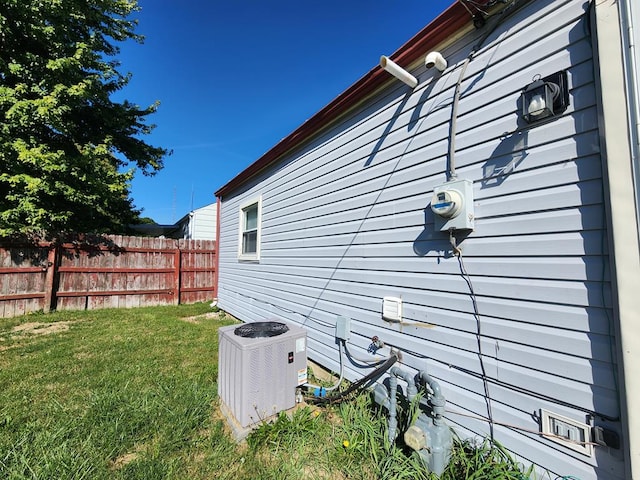 view of home's exterior with a lawn and central AC unit