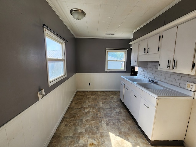 kitchen featuring backsplash, white cabinets, and ornamental molding