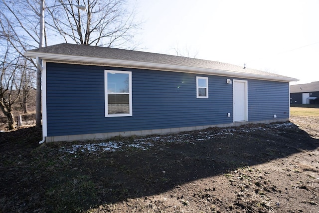 rear view of property with roof with shingles