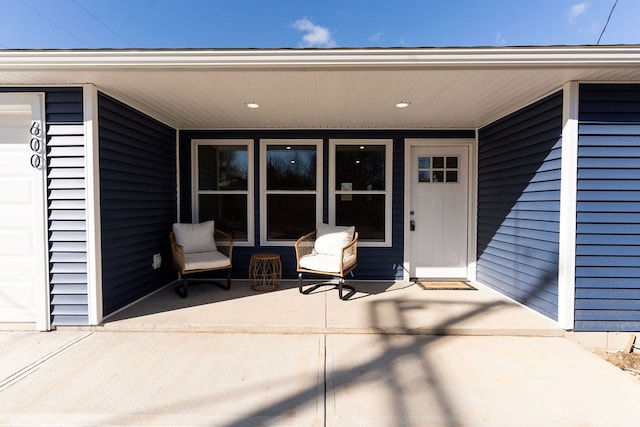 view of exterior entry with a garage and covered porch