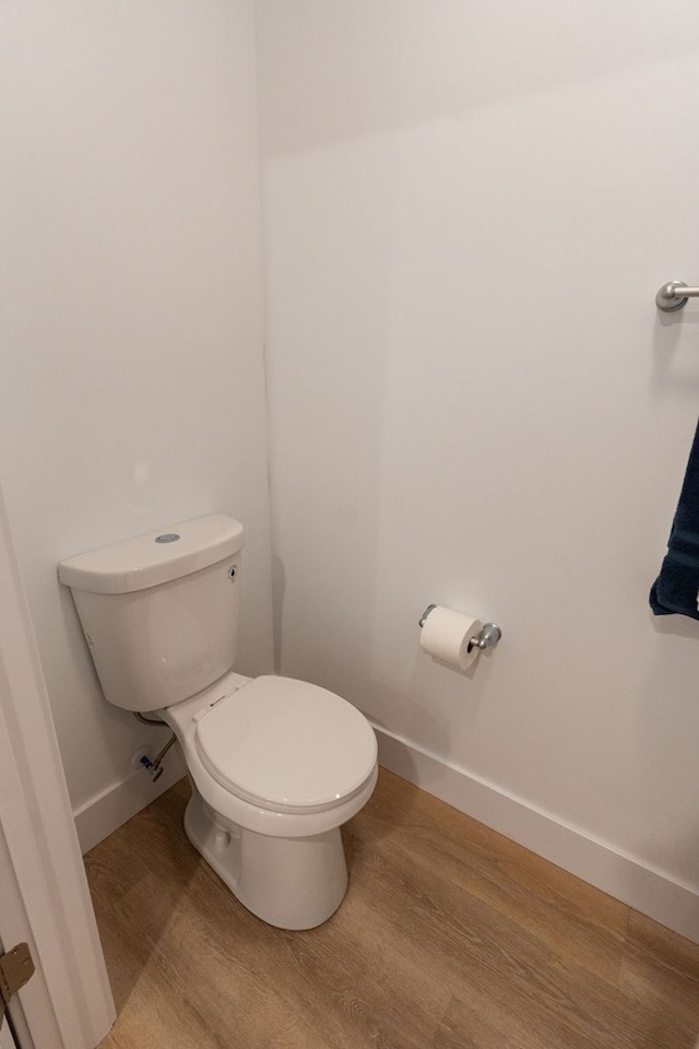 bathroom featuring toilet, baseboards, and wood finished floors