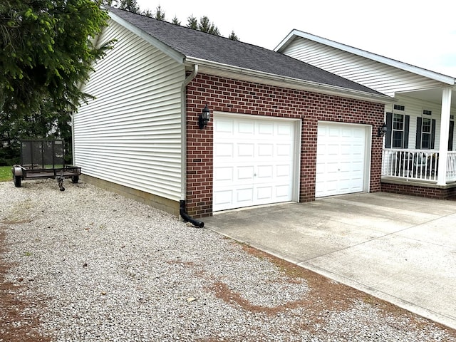 view of side of property featuring covered porch and a garage