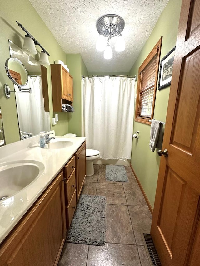 bathroom with a shower with shower curtain, a textured ceiling, vanity, and toilet