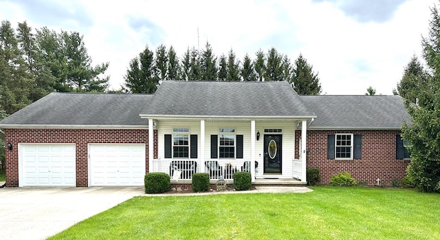 view of front of house with covered porch, a garage, and a front yard