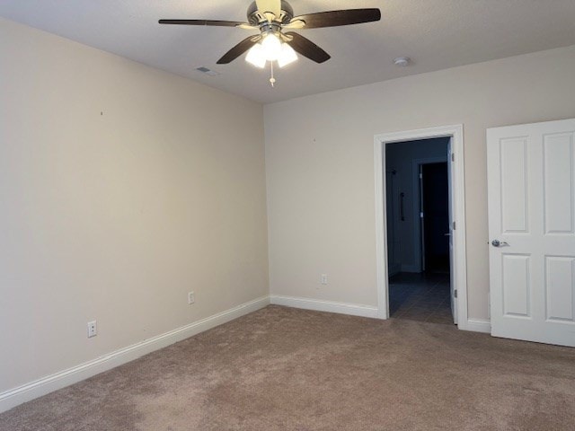 carpeted spare room with ceiling fan