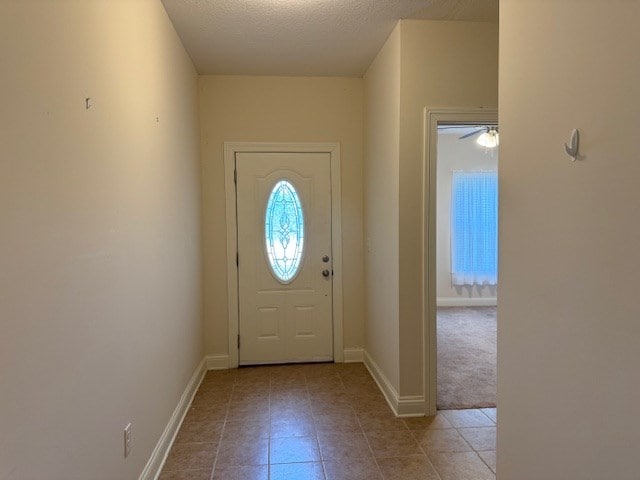 doorway featuring a textured ceiling and ceiling fan