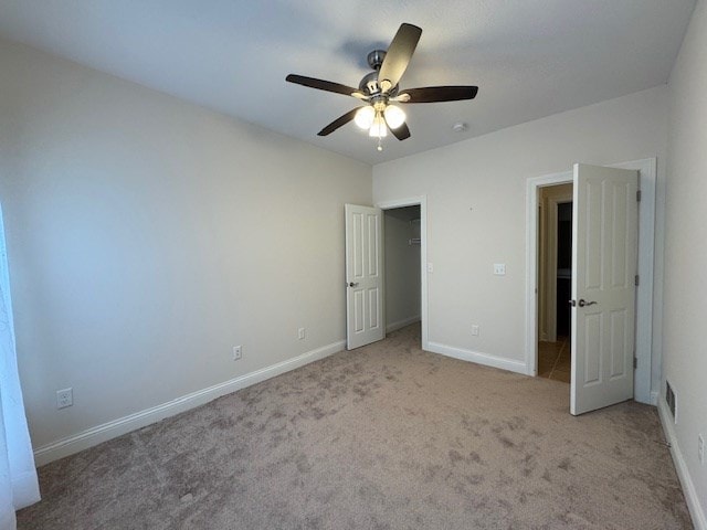 unfurnished bedroom with ceiling fan and light colored carpet