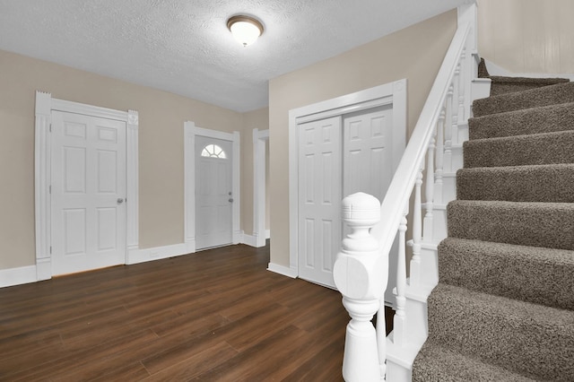 entryway featuring dark hardwood / wood-style flooring and a textured ceiling