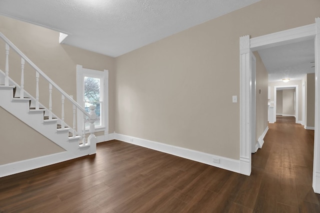 interior space with a textured ceiling and dark wood-type flooring