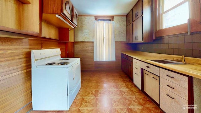 kitchen with a healthy amount of sunlight, white electric range, white cabinetry, and light parquet flooring