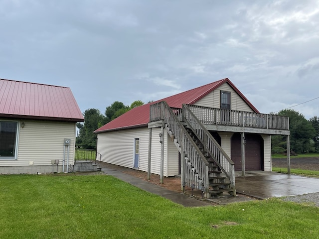 4030 Shoup Rd, Shelby, OH 44875 - back of house with a wooden deck, concrete driveway, metal roof, a lawn, and stairway