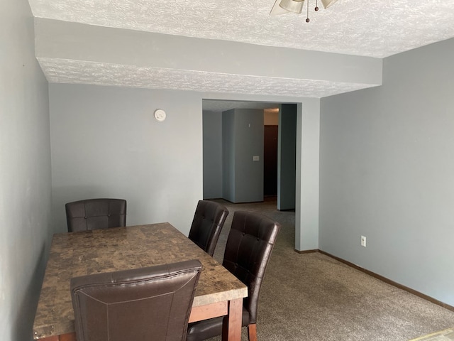 carpeted dining room with ceiling fan and a textured ceiling